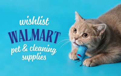 A light brown cat with wide eyes crouches on a blue background, holding a blue plush mouse in its mouth. Text reads: “Wishlist Walmart – pet & cleaning supplies.”